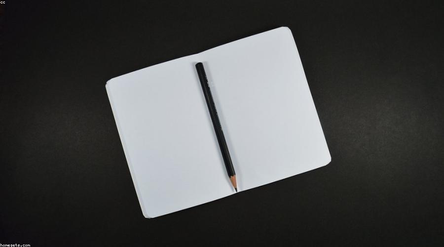 A blank sheet of cream paper on a wooden desk, waiting to be written on