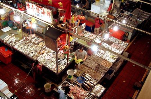 Busy morning market stalls with fresh fish and spice vendors in Little India