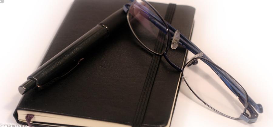 Closed black leather journal with an elastic band, kept private on a desk