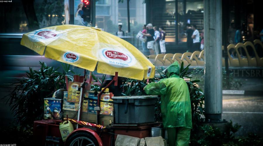 Orchard Road after rain, wet pavement reflecting storefront lights