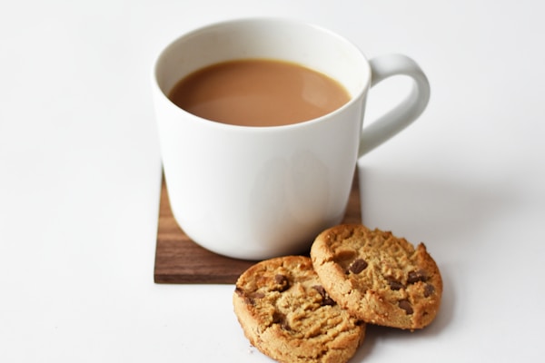 Half-finished mug of tea next to a stack of blank paper